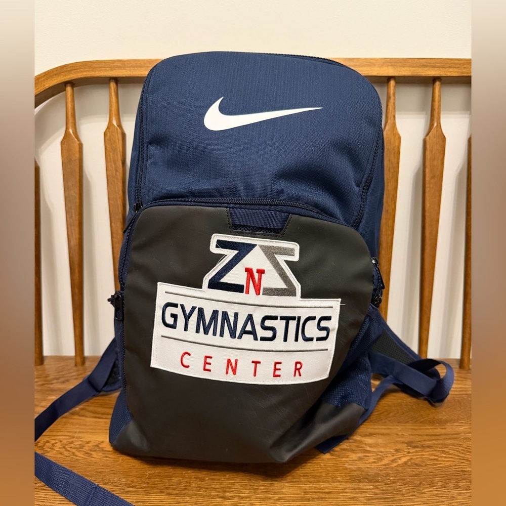 Navy blue Nike Brasilia backpack with a custom "ZNZ Gymnastics" patch on the fro